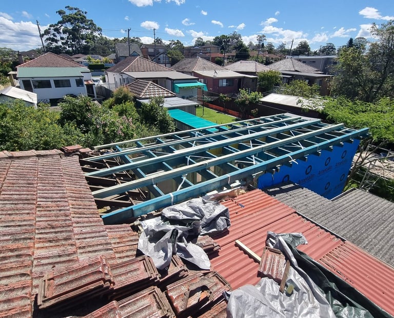 Residential roof extension under construction showing timber framing and terracotta tiles.