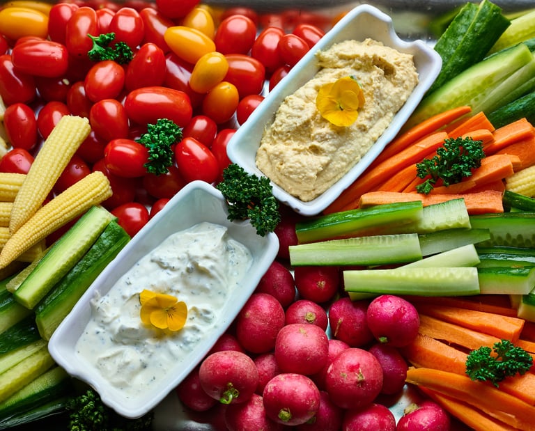 Assiette de crudités fraîches avec houmous, carottes, concombres, radis et tomates