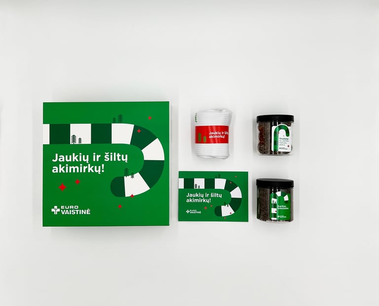 Eurovaistinė holiday gift set with green gift box, cozy socks, and two jars of herbal tea.