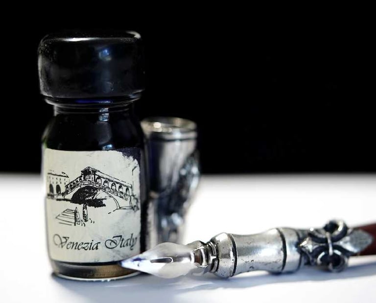a bottle of ink ink and a pen on a table