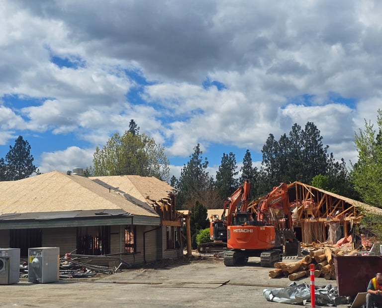 Two excavators demolishing a large structure