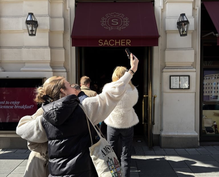 Turistas haciendo fotos y haciendo cola frente al icónico toldo granate de la entrada
