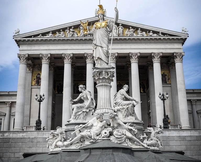Vista frontal del Parlamento de Austria en Viena con la Fuente de Atenea en primer plano.