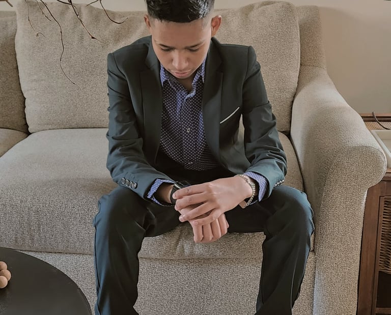 Young Creator and Neurodivergent artist wearing a suit and checking time