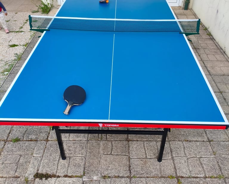 Mesa de ténis TOPGIM Training aberta no exterior com raquete e bola — vista aérea