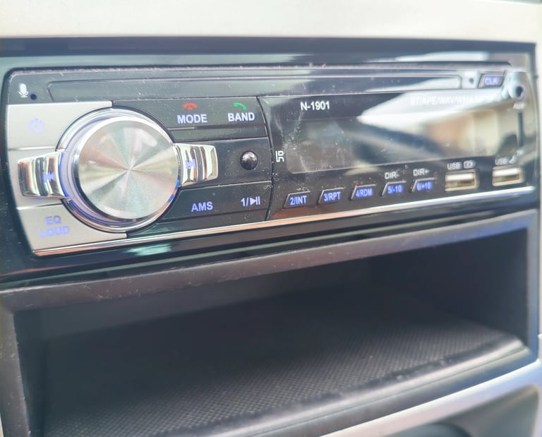 Análise de acabamento e relevo do botão de volume cromado no auto-rádio N-1901 visto de lado.