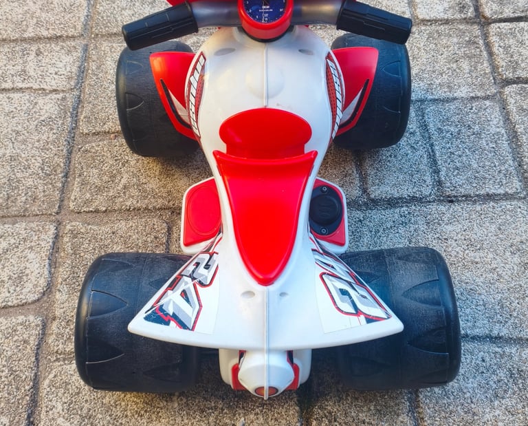 Vista de cima da Moto 4 elétrica Injusa Wrestler 6V com guiador e assento vermelho visíveis