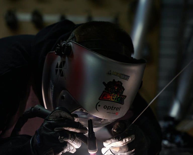 a man welding a metal object in a factory