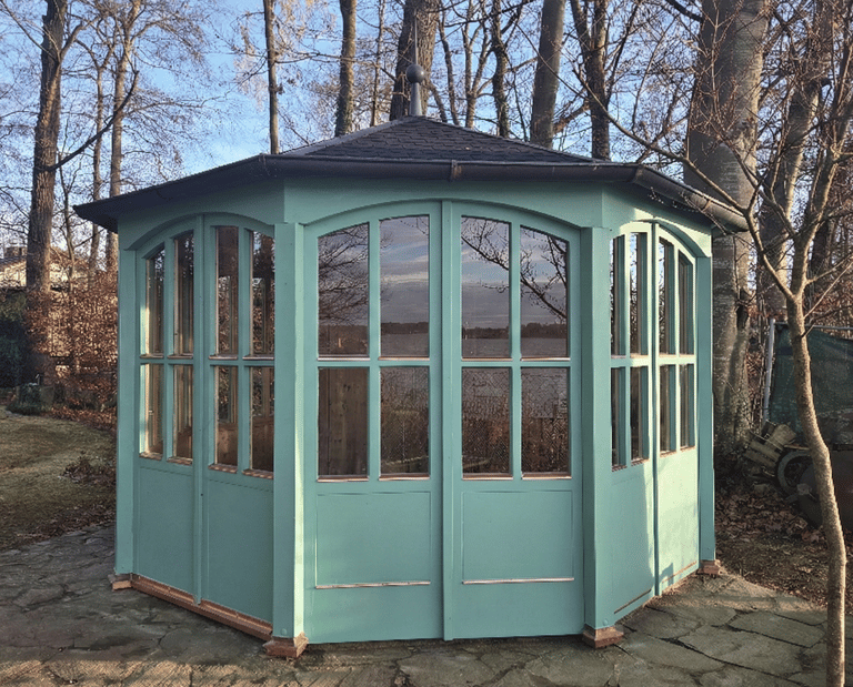 Maßgefertigter Holz-Pavillon in Türkis mit großen Sprossenfenstern und Kupferdach direkt am Seeufer am Ammersee.