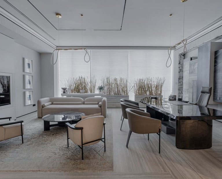 Modern luxury executive office interior with a black marble desk, cream lounge chairs, and minimalist decor.