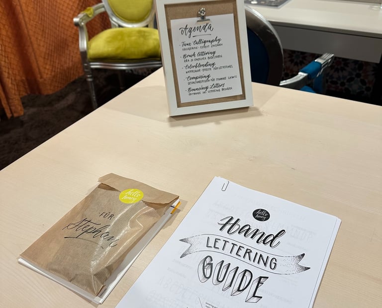 Hand lettering guide and workshop agenda on a desk for a creative calligraphy class.