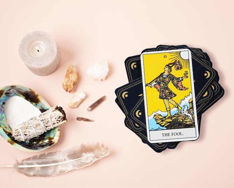 The Fool tarot card on a stack with crystals used in beginner tarot course.