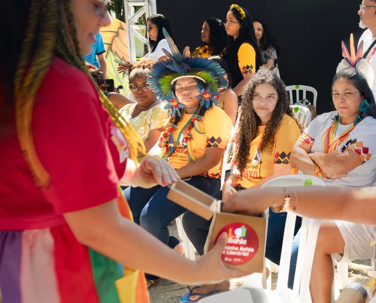 Mulheres sentadas em uma feira literária indígena
