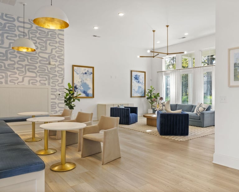 Interior clubhouse seating area with tables and accent lighting at Evoke Living at Morris Field in Charlotte, NC