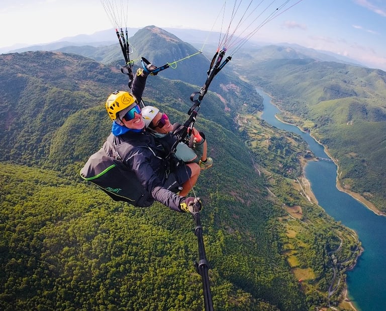 Volo in parapendio biposto sopra la Valle Reatina, esperienza outdoor con vista su lago e montagne vicino a Rieti