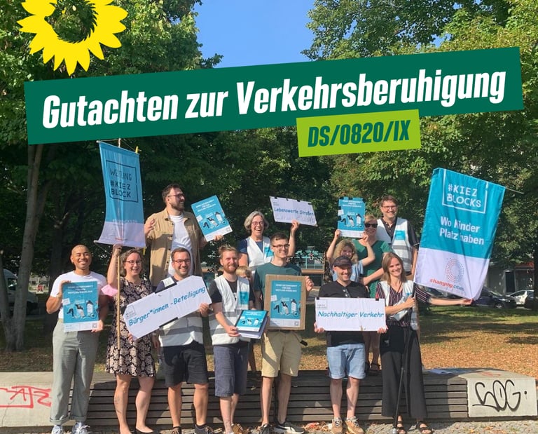 Sharepic zum Antrag, das ein Foto einer Gruppe gutgelaunter Menschen mit Plakaten zeigt.