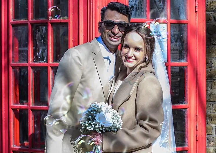 Newly-weds standing in front of a London telephone box