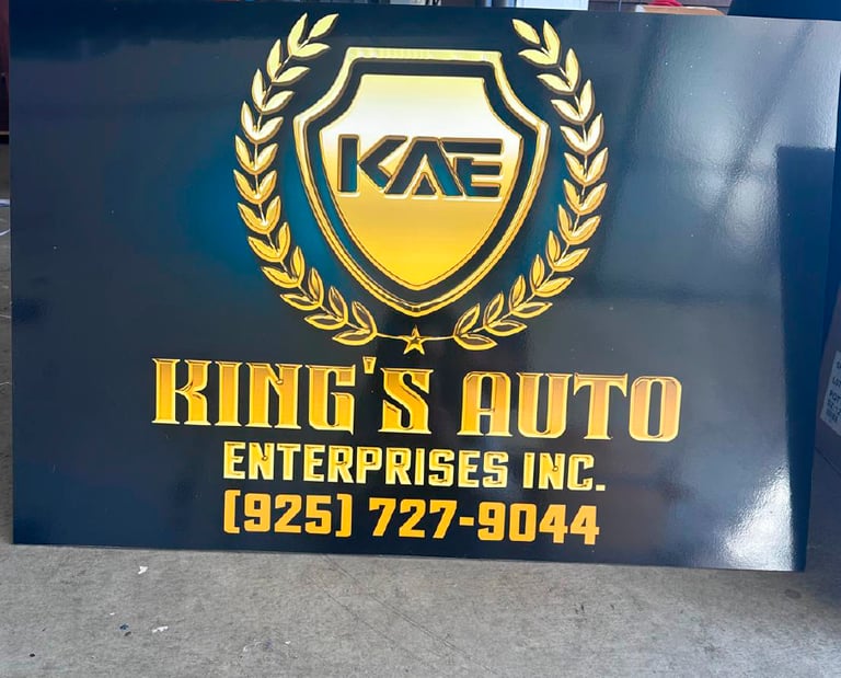 Custom black and gold King's Auto Enterprises sign featuring a shield logo and contact number.