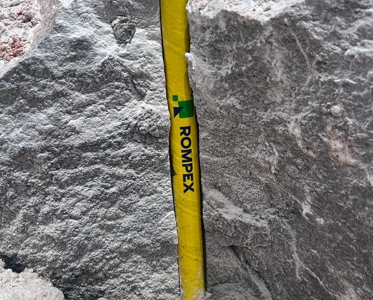 Cápsula amarela Rompex para desmonte de rochas dentro de um furo de uma rocha