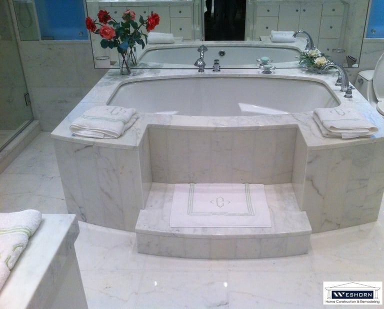 Luxury white marble bathtub with custom stone tile steps and elegant bathroom decor.