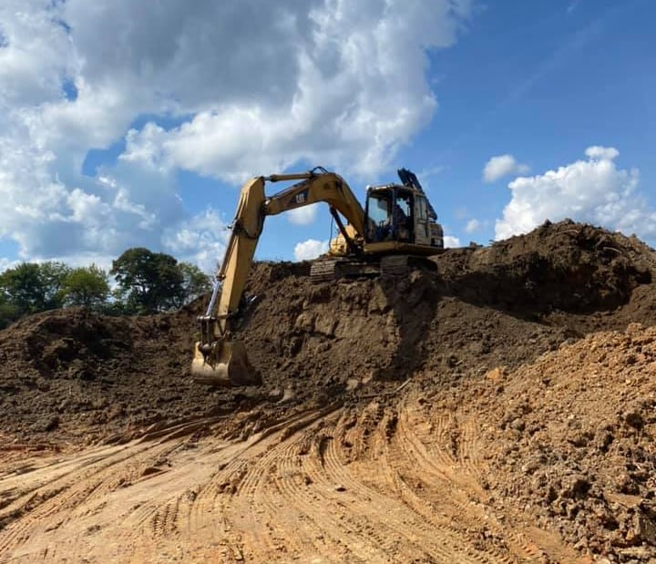 Large Excavator digging out land area, excavating
