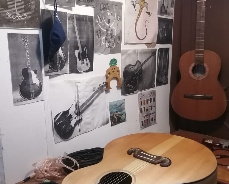 Guitarra acústica sobre un banco de trabajo de luthería, con bocetos de guitarras y herramientas  