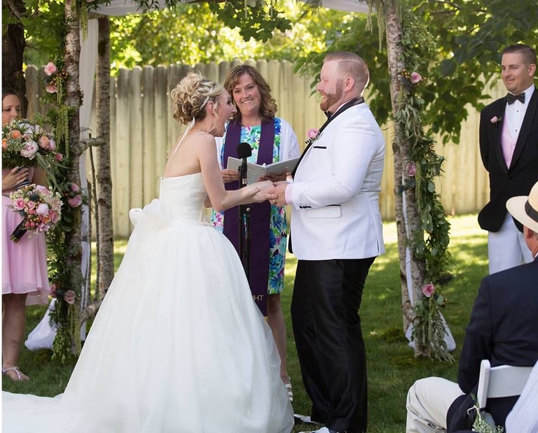 Wedding officiant with couple during outdoor wedding ceremony