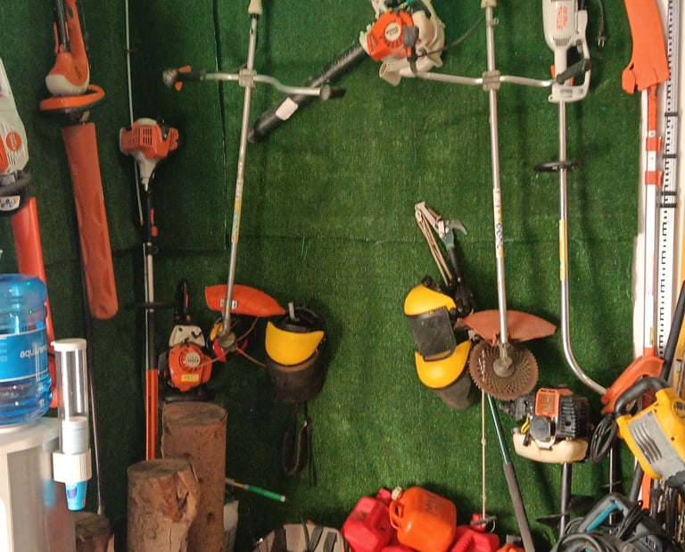 Professional Stihl chainsaws and garden power tools displayed on a green turf wall in a hardware store.