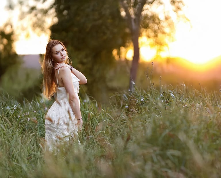 une jeune femme pose pour une séance photo au soleil couchant