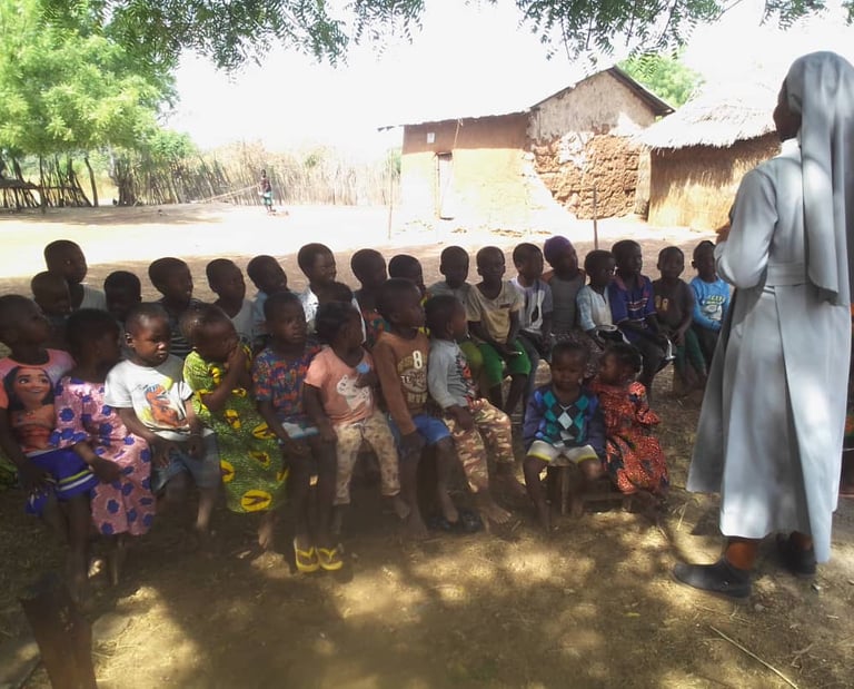 Missionary sister teaching children outdoors in Ghana community
