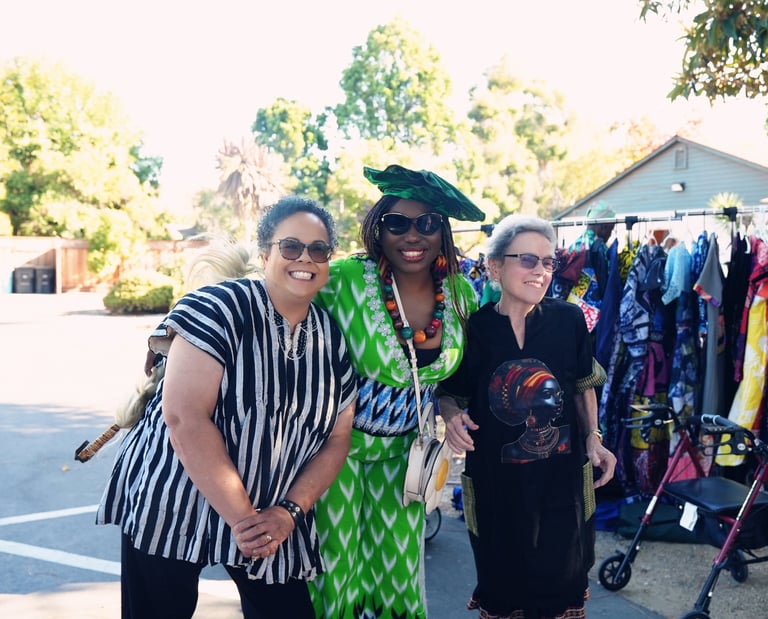 two women standing in front of a rack of clothes