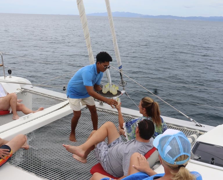 Professional crew providing personalized service to guests on luxury catamaran tour in Costa Rica