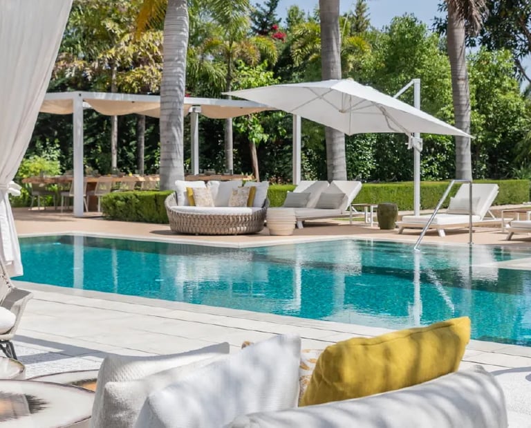 Villa Serenity poolside with daybeds and chic white pergola