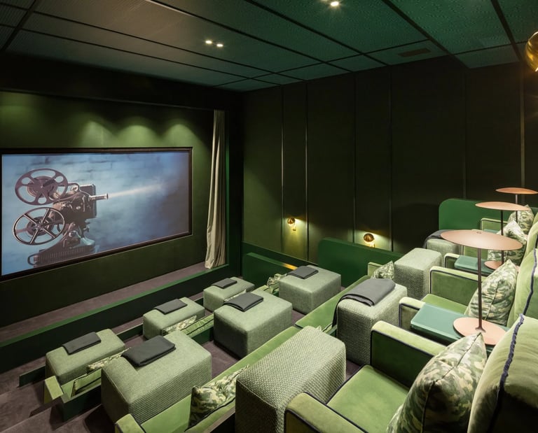 Cinema room at Villa La Gratitud with plush green armchairs