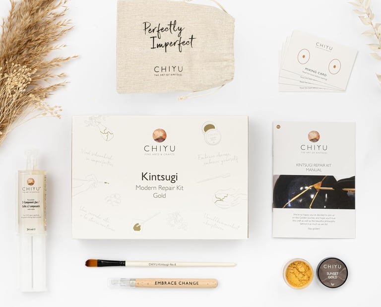 Kintsugi repair kit with gold powder, tools, and manual for mindful ceramic restoration at home.