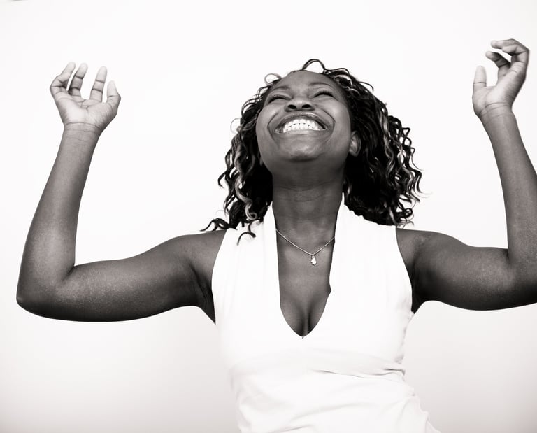 Femme qui rit et lève les mains au ciel
