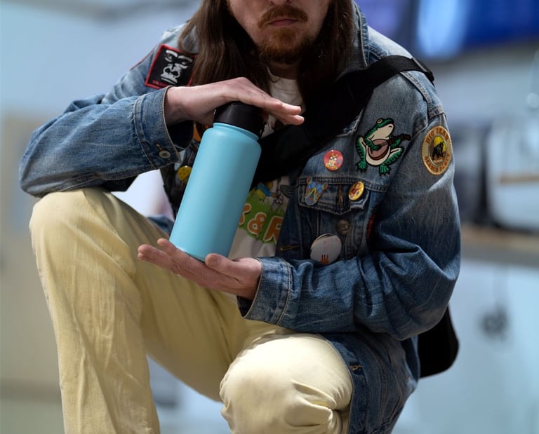 Portrait of a fashionably dressed man holding a blue water bottle