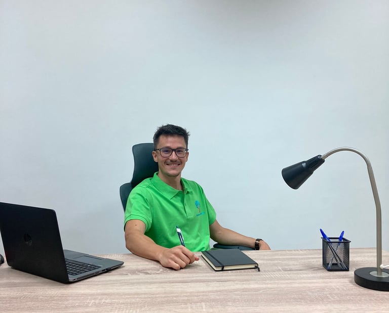 a man sitting at a desk with a laptop and a laptop