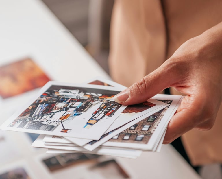 a person holding a bunch of photos doing a choice for the creation of a unique luxury print