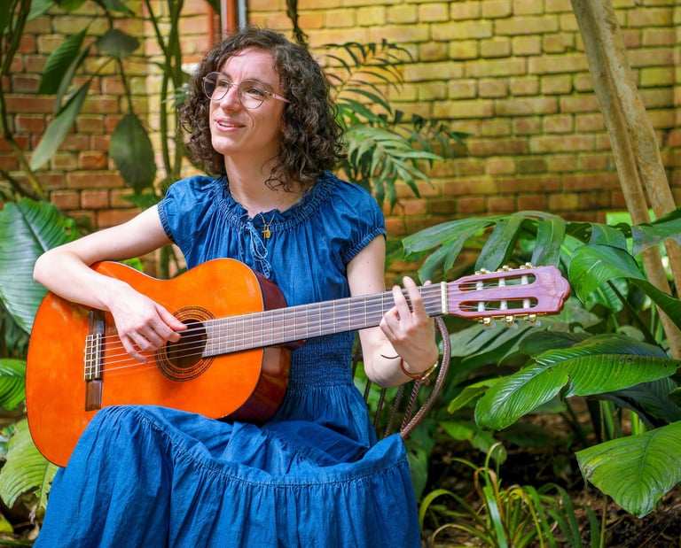 chanteuse guitariste en robe bleue chantant dans une serre