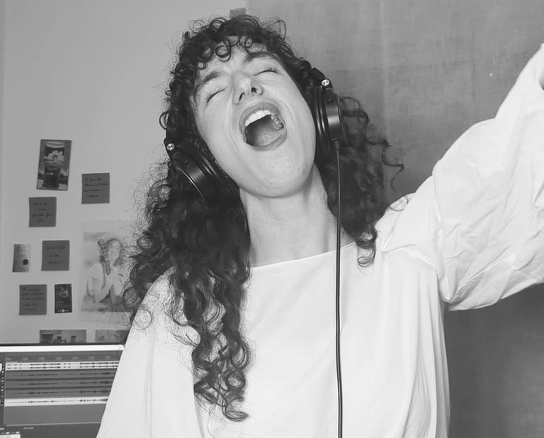 photo en noir et  blanc de aude fy en train de chanter avec casque sur les oreilles