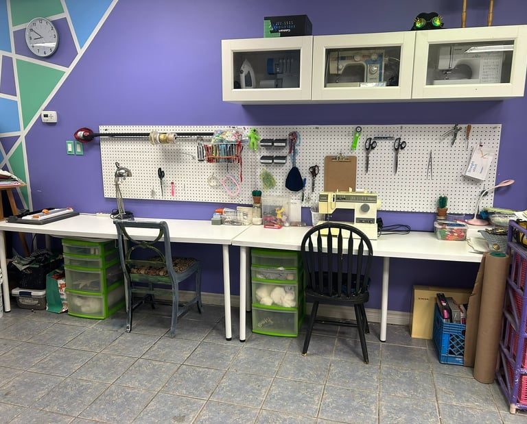 two desks with chairs, and a selection of sewing supplies and notions