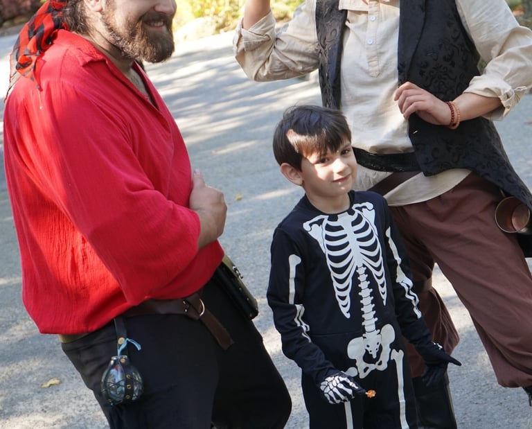 Pirates pose with a kid at a halloween event