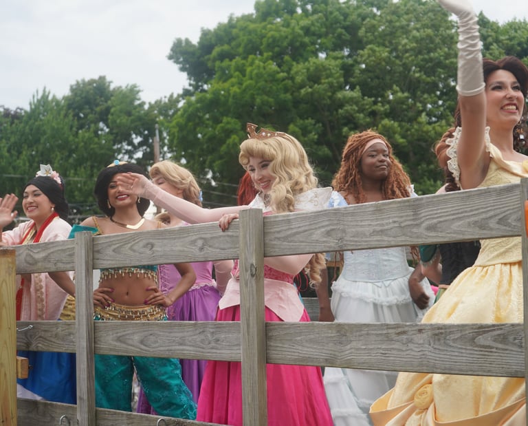 Princesses wave at guests during a parade