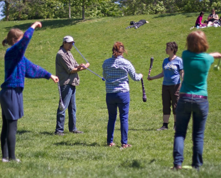 The Pyroneer teaching group Poi lesson in a park./