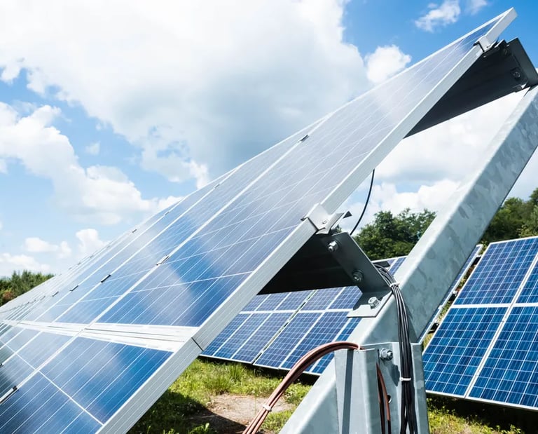 Fotografía de lado y desde abajo de paneles solares para industria de manufactura color azul con contornos blancos.
