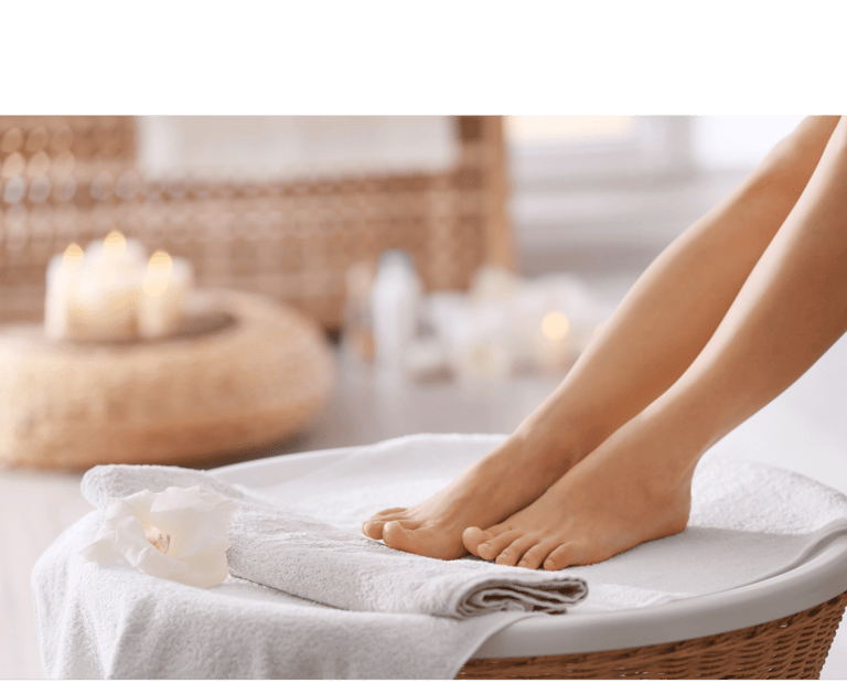 Verzorgde voeten rustend op een handdoek met sfeervolle kaarsen op de achtergrond bij Medisch Pedicure Grote Berg.
