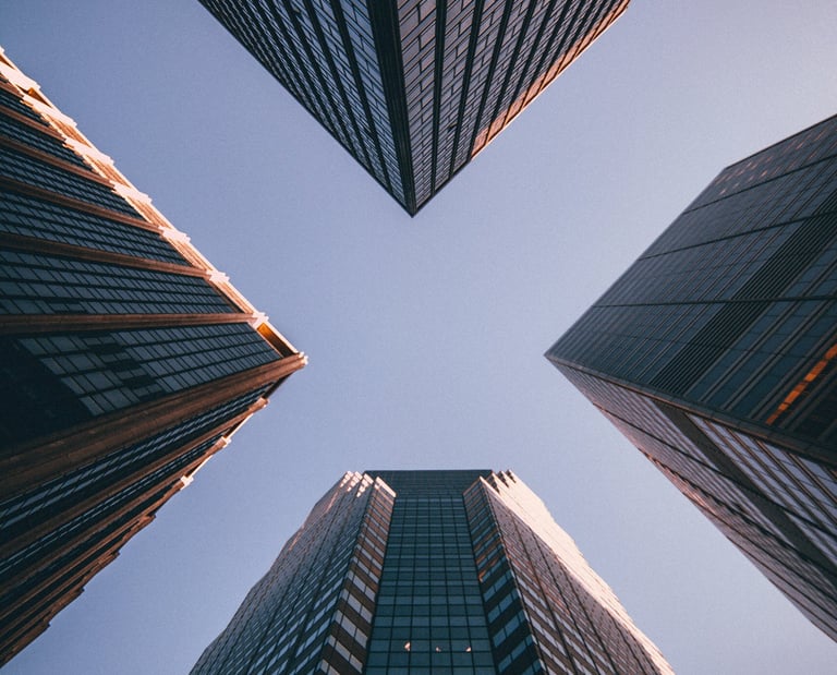 Photograph of a towering office building with blue sky above