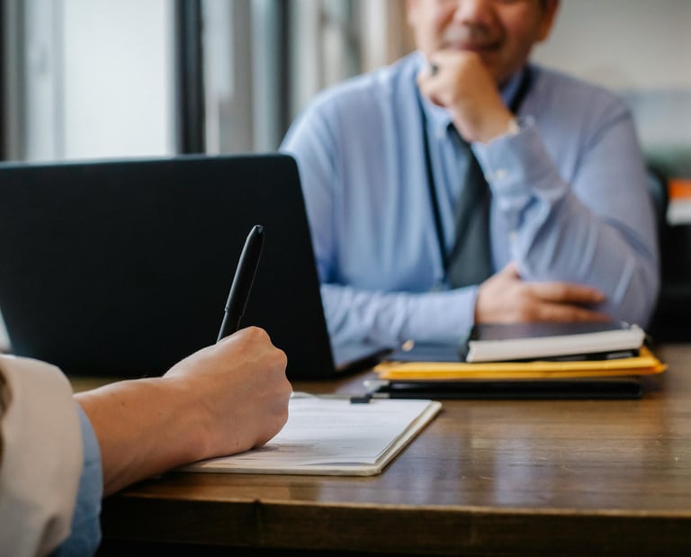 a man sitting at a table with a notebook and pen