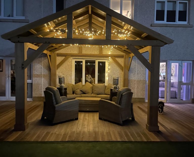 Modern Gazebo with feature lighting, patio heaters and large sofa.